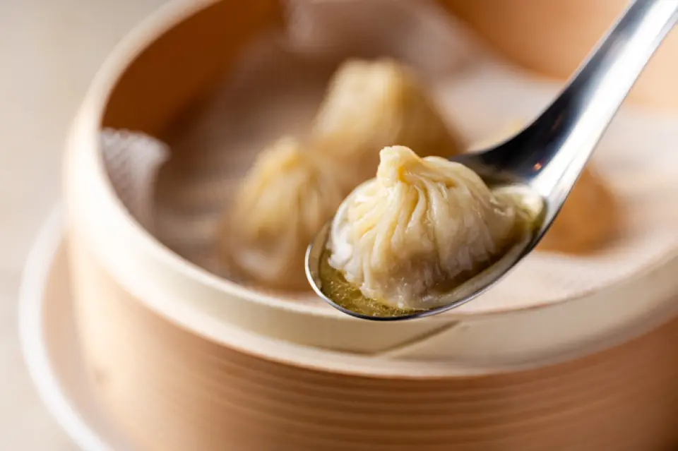 這些薄皮小籠包是用代代相傳的陳年麵糊做成的！這道湯味道濃鬱，製作耗時 7 小時。我們提供各種口味的小籠包，包括可以讓您享受食材味道的原味，以及松露和蟹味噌口味。我們也提供以當季食材製作的湯餃，目前有牡蠣湯餃可供選擇。