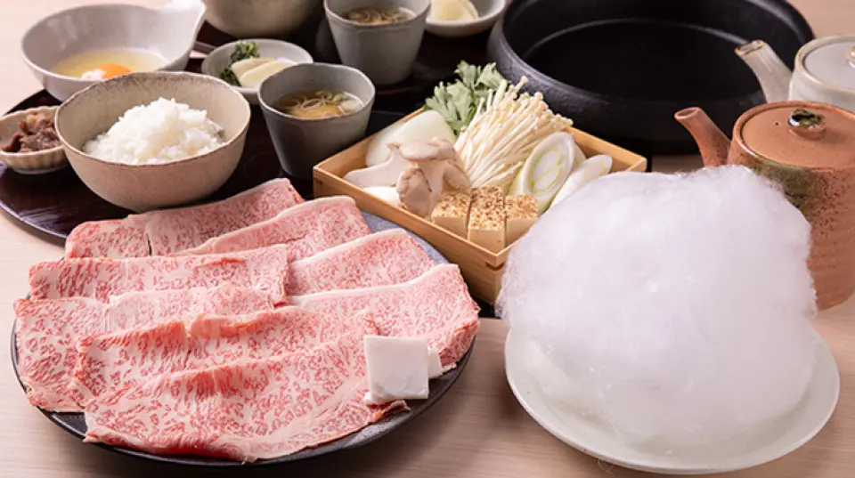 本店的壽喜燒採用日本引以為傲的A5級黑毛和牛製作，是值得驕傲的推薦菜色。這道菜是將類似蛋白霜的蛋白與蛋黃混合而成的，因此即使不喜歡生雞蛋的人也可以享用它。套餐中還包含蔬菜拼盤、米飯、味噌湯、醃菜、和牛佃煮，並以淋上特製醬汁的甜棉花糖呈現，令人賞心悅目。請盡情享受我們特製的湯汁所帶來的傳統日本風味。
