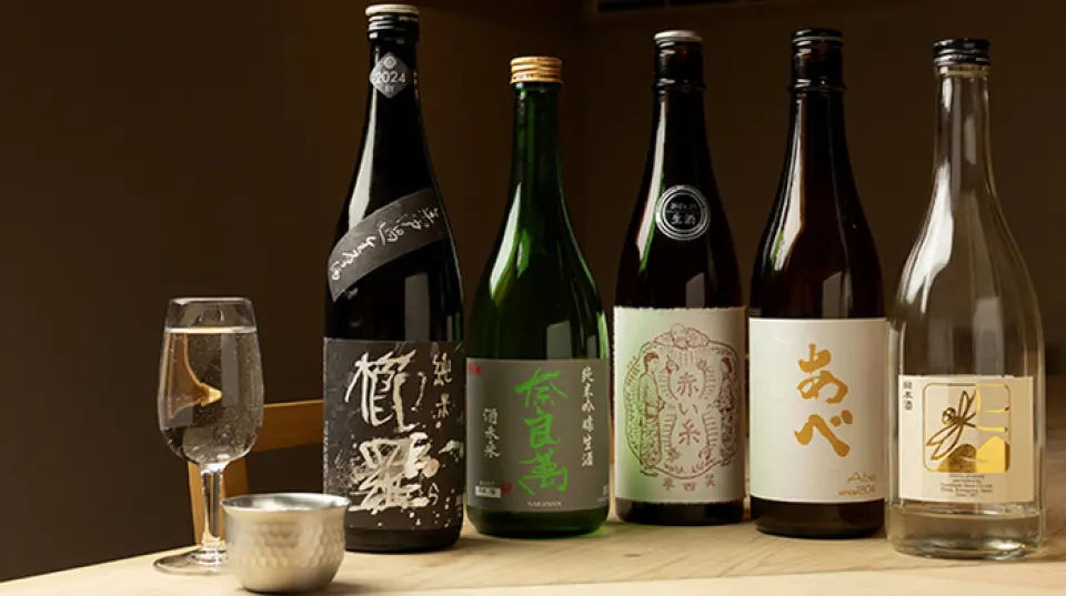 本店常备有来自日本全国各地的约20种精选日本酒。丰富的产品阵容不仅包括知名品牌，还包括尚未广为人知的美味日本酒。店主是一名经过认证的酒侍酒师，他精心挑选和采购酒。我们提供 90 毫升或 60 毫升的小份，因此您可以轻松尝试不同类型。我们提供不断变化的香料酸味酒和水果利口酒供您在光临时享用。