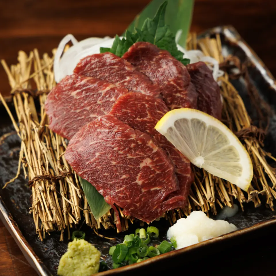 我们提供使用熊本县的新鲜马肉制成的瘦生鱼片、雪花生鱼片和刺身！红鱼生鱼片是一道味道鲜美、健康美味的菜肴！大理石纹生鱼片的甜度极佳，入口即化的口感！刺身表面经过轻微煎烤，散发出阵阵香气，每一口都带着浓郁的口感！请品尝一下只有使用熊本县马肉才能品尝到的绝妙菜肴！