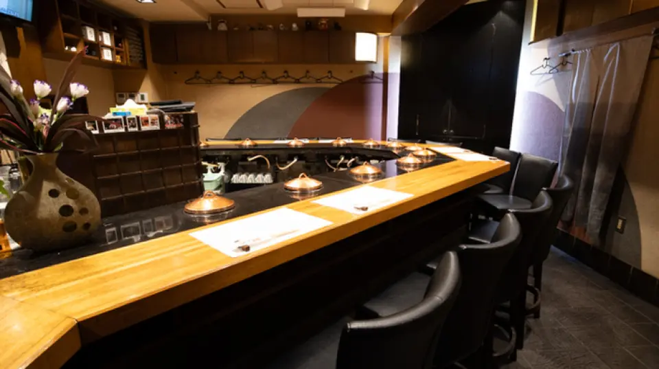 我們的餐廳位置便利，距離心齋橋站僅 5 分鐘步行路程。吧台設有 16 個座位，是您一邊用餐一邊愉快交談的絕佳場所。隔壁的附屬建築也設有櫃檯座位。您可以在日式空間內享受溫馨輕鬆的時光。