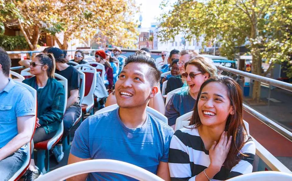Tourists aboard an open-air tour bus in Sydney
