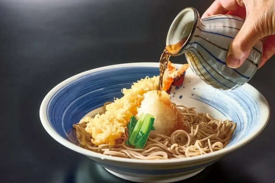 我每天早晚都精心准备汤料。这是因为汤汁的味道会随着时间的推移而变淡。我们的正宗高汤由精选适合该地区的原料混合而成，包括鲣鱼片，具有浓郁的味道和香气，进一步增强了我们引以为豪的荞麦面和乌冬面的美味。