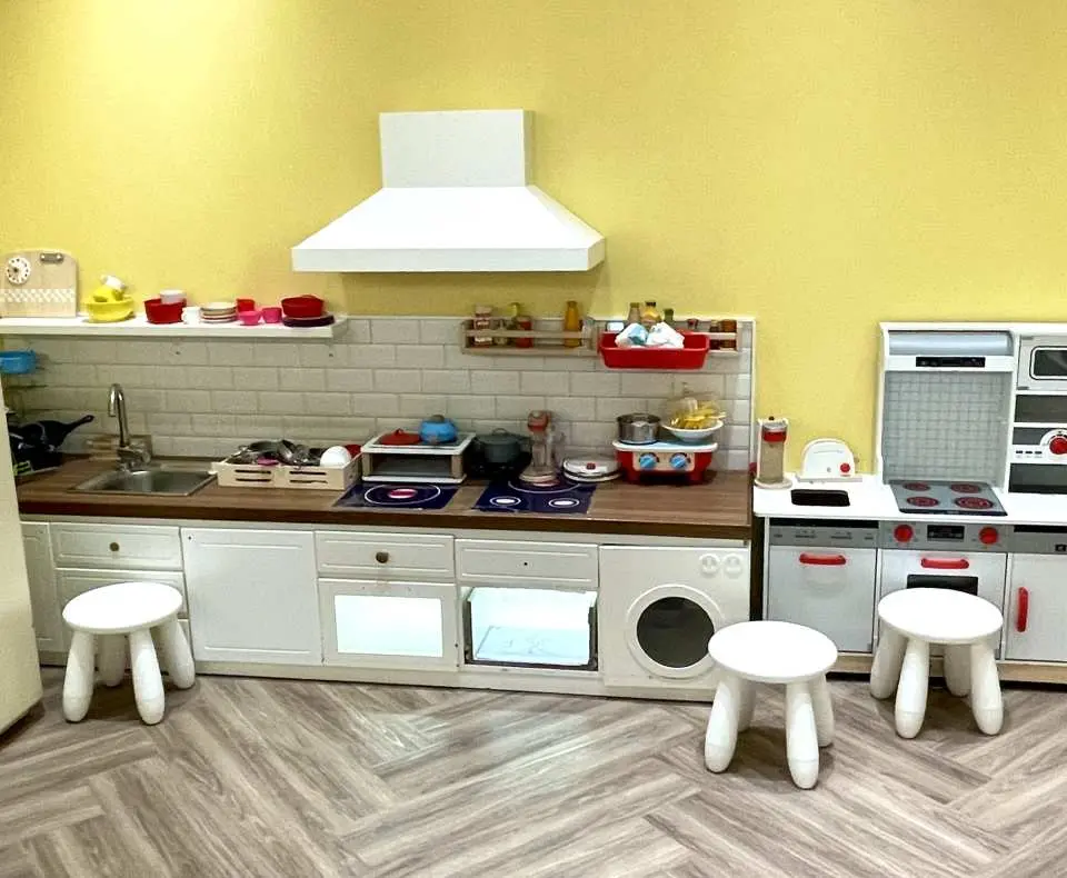 Whizbo Kids Cafe的仿真小廚房煮飯仔區，設有齊全的爐具、水槽和烤箱玩具，配搭小凳子，讓孩子們體驗烹飪樂趣。