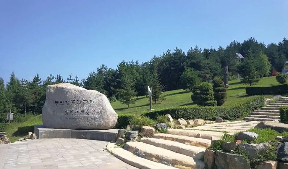 용정 또는 명동촌의 풀밭 언덕에 있는 한글 비석이 새겨진 큰 기념비. 나무와 계단으로 둘러싸여 연변 문화 투어의 핵심입니다.