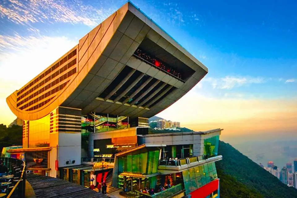 The distinctive bowl-shaped exterior of The Peak Tower, a landmark on Victoria Peak, looks majestic under the sunset glow, serving as Hong Kong's highest observation deck.