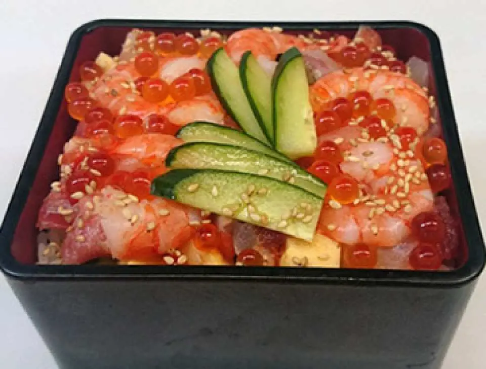 一碗色彩豐富的海鮮丼飯，鋪滿新鮮蝦仁、鮭魚卵、切片生魚片與黃瓜，是屋形船豪華餐點之一。