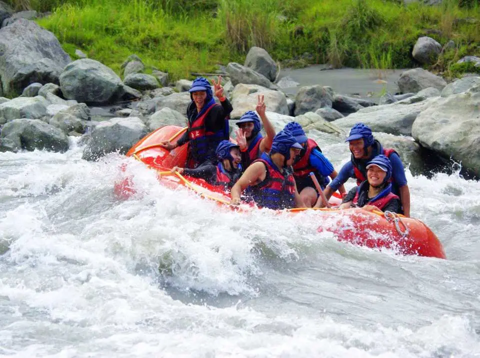 紅色泛舟艇載著冒險者，在花蓮秀姑巒溪的白色急流中奮力划行，享受團體出遊的樂趣。