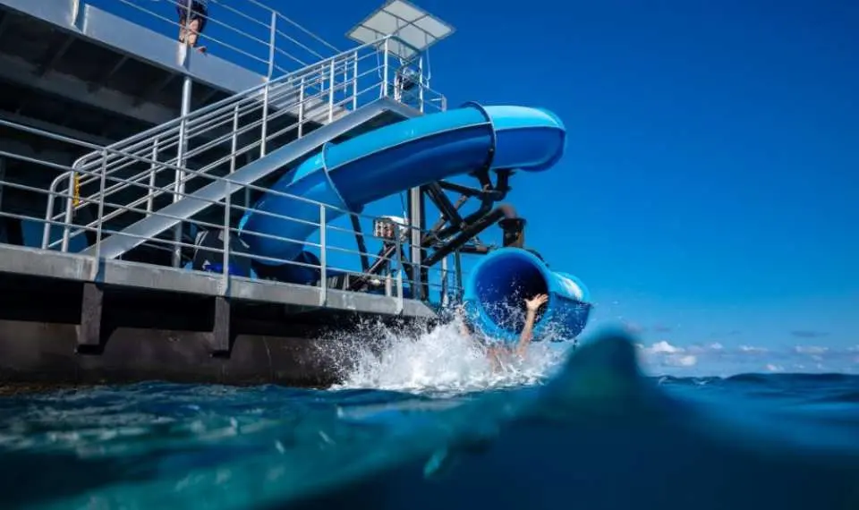 凱恩斯摩爾大堡礁太陽戀人號，遊客從刺激的水上溜滑梯直接滑入清澈的海洋，體驗清涼暢快的樂趣。