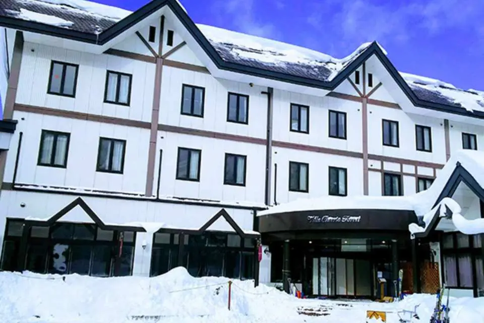 The charming exterior of a ski resort hotel at Kita-Shiga Ryuoo Ski Park, snow-covered and offering convenient ski-in/ski-out access for guests.
