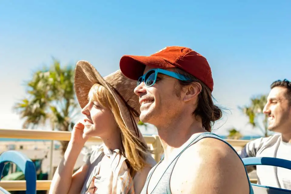 ロサンゼルスBig Busのオープントップ観光バスで、晴れた日に街の景色を楽しみながら笑顔の観光客。乗り降り自由な旅を満喫しています。