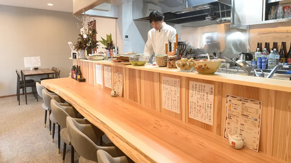 本店交通便利，靠近車站，氣氛輕鬆愜意，宛如日式餐廳。一棵杉木打造的吧台座位，讓您感受木材的溫暖，一邊欣賞現場烹飪，一邊與店員暢談。桌椅座位可依人數調整，適合各種場合。歡迎光臨。