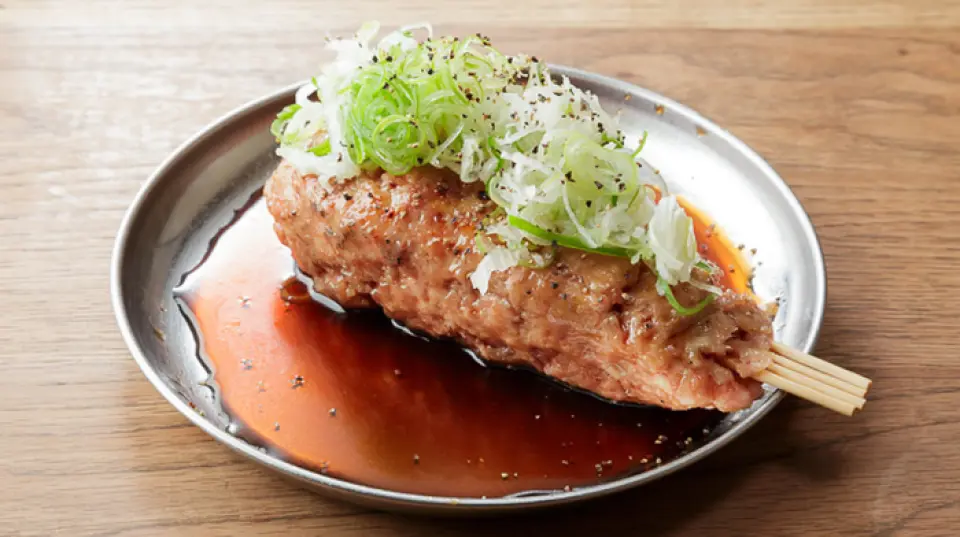 我们的肉丸子，用了足足250克的肉末，个头爆表！用四根烤肉签串起来，在炭火上慢慢烤30分钟左右。加100日元，可以添加浓釉或蛋黄酱等酱料，或者加奶酪、鸡蛋等配料。个头很大，适合所有人分享。而且250日元的价格也很合理！请务必品尝。