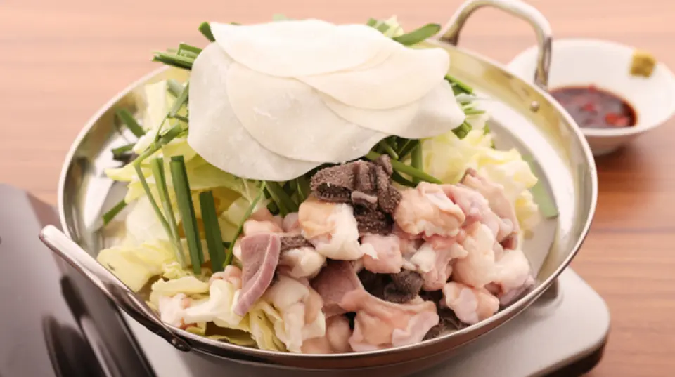 Nhà hàng của chúng tôi chuyên về "Motsunabe kiểu Mizutaki" độc đáo, khác với motsunabe làm từ miso và nước tương thông thường. Súp gà hầm kỹ trong hơn 10 giờ, nhẹ nhưng có hương vị đậm đà với vị umami của gà cô đặc. Thưởng thức cùng nước tương giấm đặc biệt của chúng tôi, có hương vị mềm và dịu nhẹ chỉ có thể đạt được khi tự làm. Chúng tôi liên tục nhận được các yêu cầu về việc mang món ăn tuyệt vời này ra. Bạn cũng có thể mua motsunabe trực tuyến để thưởng thức hương vị của chúng tôi ngay tại nhà.