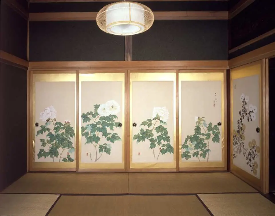 小樽貴賓館（青山別館）の優雅な日本間内部。畳敷きの床に、精巧な牡丹の花が描かれた襖絵が、明治時代の繊細な職人技と芸術性を際立たせています。