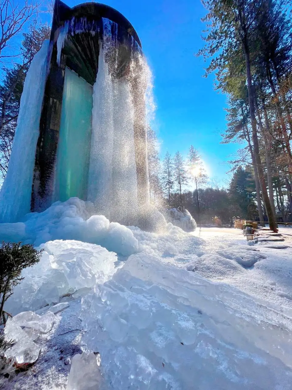 南怡島冬季特色景觀，結冰的瀑布形成壯觀的冰柱與冰層，水流從中穿透而下，展現冰雪奇觀。