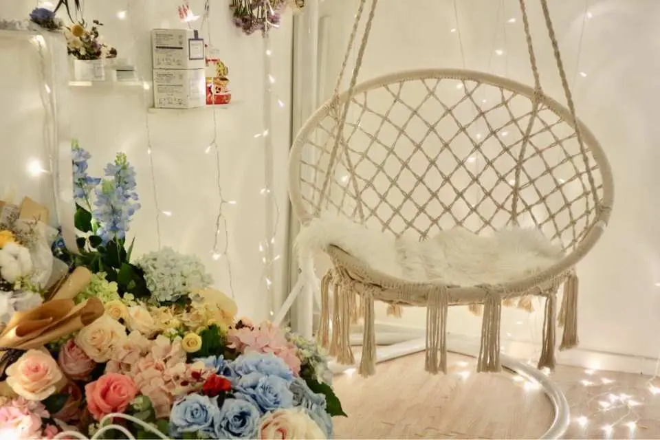 觀塘Myosotis.flower工作室內，佈置著舒適的波希米亞風吊椅，周圍環繞著閃爍燈串和鮮花，是拍照留念的理想角落。