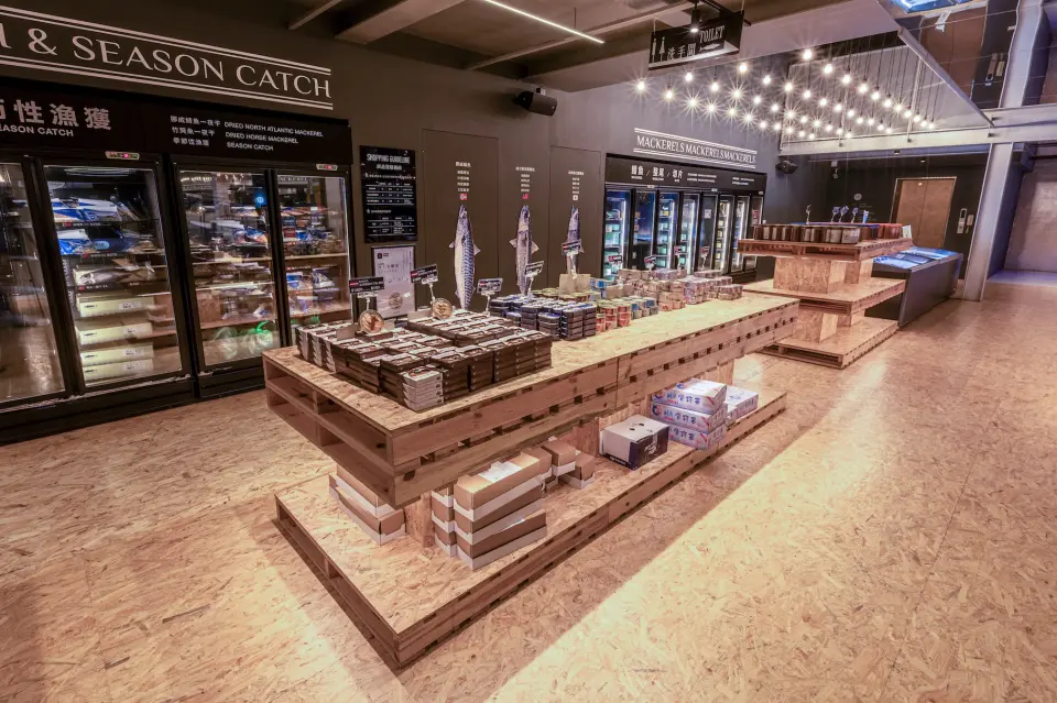 蘇澳大サバ夢工場のお土産エリア。素朴な木製パレットには様々なサバ製品が並び、鮮魚から創造的な加工品まで、地元の特産品が豊富に揃っています。