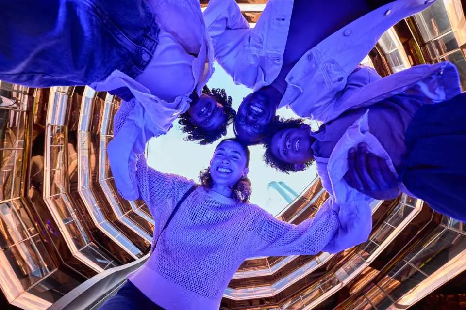 一群朋友從Vessel頂部向下俯視，以獨特視角捕捉歡樂時刻，周圍環繞著科幻感的藍紫色燈光。