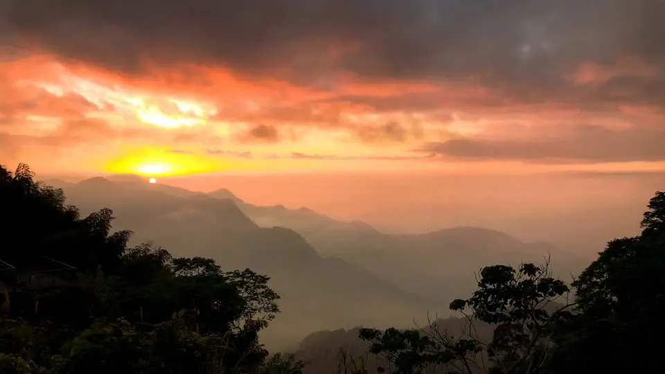 阿里山壮丽的夕阳山景，金黄与橘红色的天空下，山峦云雾缭绕，为嘉义包车一日游带来难忘的高山美景。