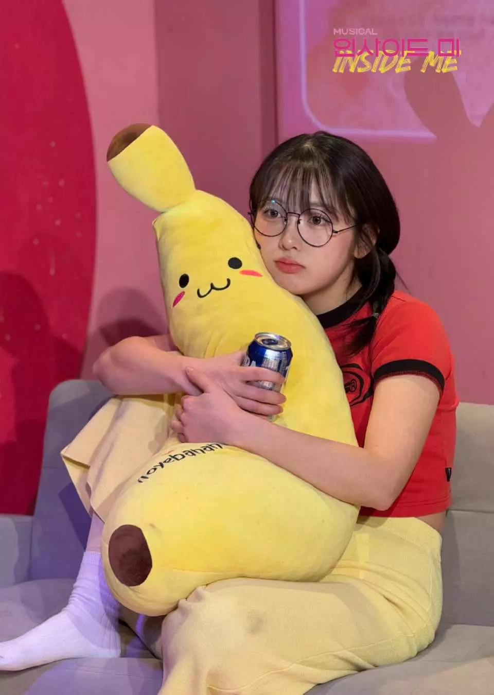 ミュージカル「私の心の中」の舞台で、女優がバナナの抱き枕と飲み物を抱え、真の自分を探す感動的な瞬間を優しく表現しています。