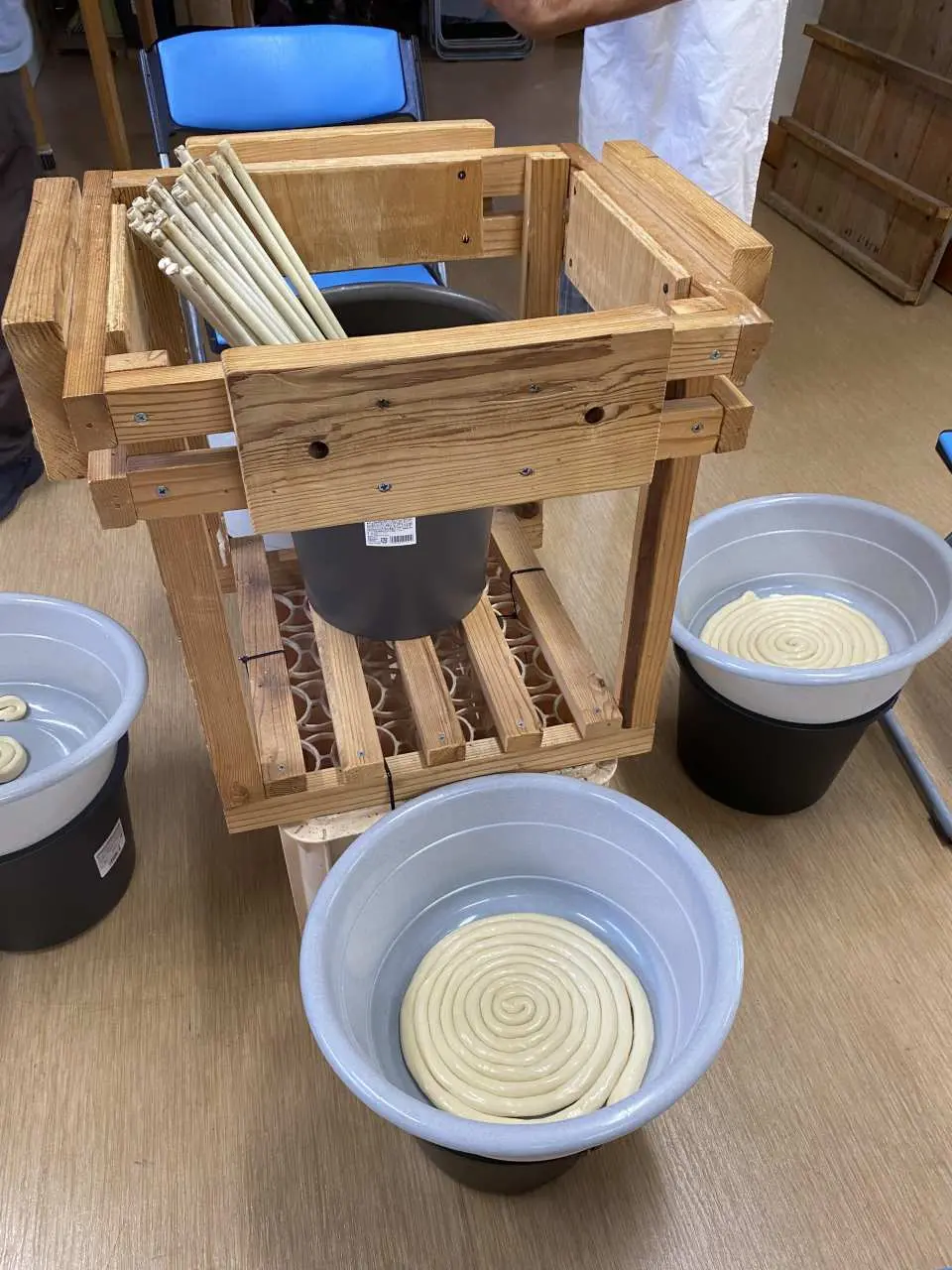 In the Goto Udon making experience, prepared dough is coiled in a bucket, showcasing the initial kneading and shaping results of the traditional craft.