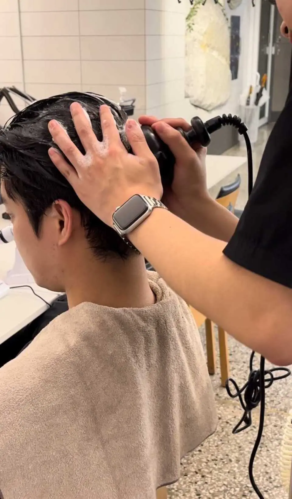 JUNO HAIR professional stylist provides meticulous haircutting service for a male client, focusing on the nape hairline to create a neat, stylish look.