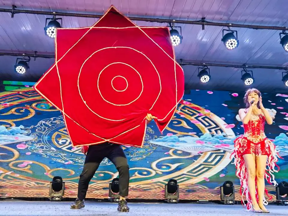 哈尔滨雪乡地道的东北二人转表演，舞台上身着华丽服饰的演员们，通过传统歌舞与道具互动，为游客呈现充满地方特色的民俗文化。