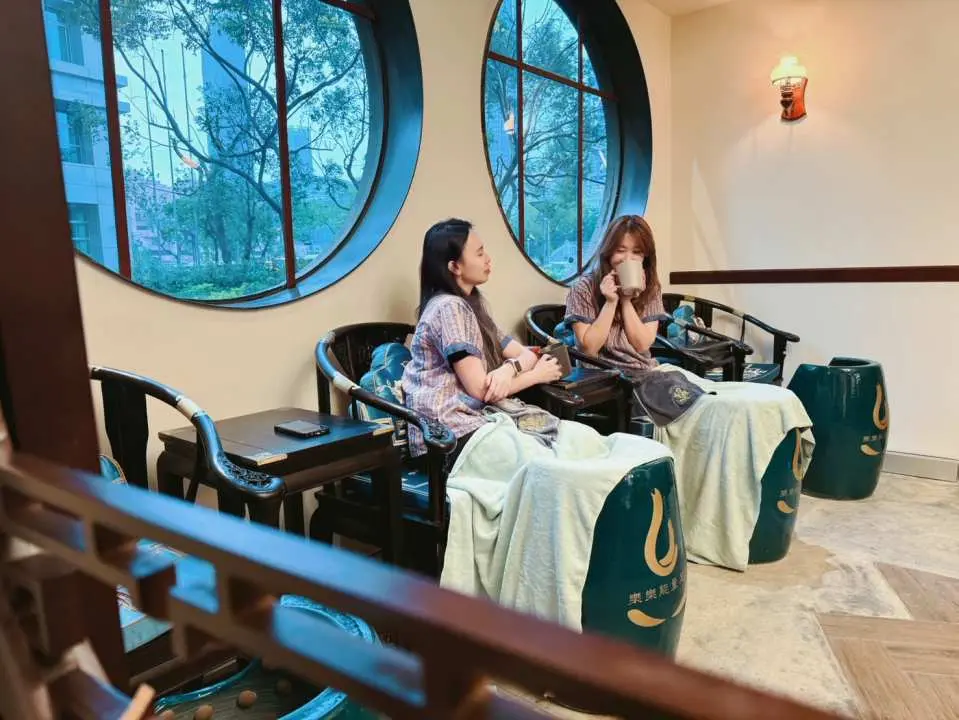 台北樂樂汗蒸幕內，兩位女士在典雅環境中舒適地享受高科技負離子足浴，放鬆身心，享受獨特汗蒸體驗。