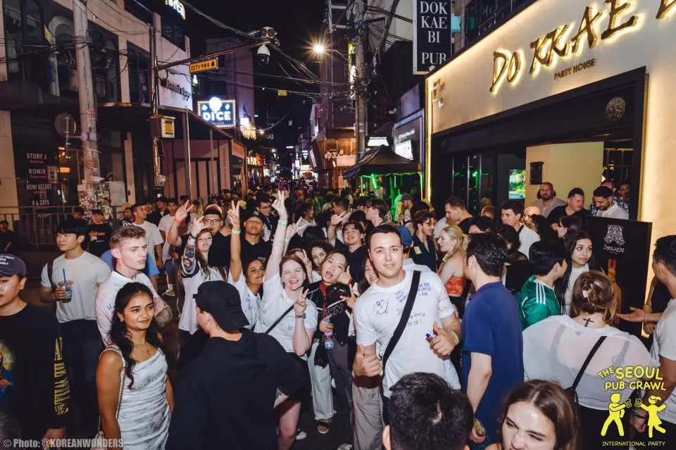 首尔弘大或梨泰院酒吧巡游时，夜晚热闹非凡的街头挤满了人群，展现亚洲派对之都的活力。