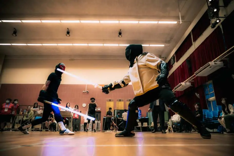 Two lightsaber enthusiasts intently sparring with glowing weapons at Starblade's Hong Kong training class, mastering advanced offense and defense techniques for real combat.