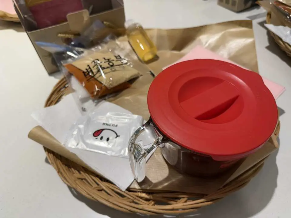 韓國美食體驗中製作辣椒醬的所需食材，包含紅色容器和各種包裝好的醬料，準備親手體驗傳統韓式料理DIY。