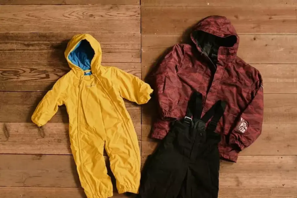 Rental ski wear available at Togakushi Ski Resort, including a yellow children's snowsuit and an adult's red ski jacket with black pants.