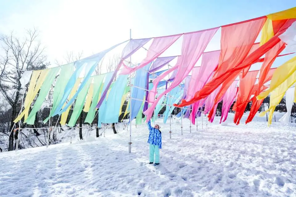 小朋友喺箱館山滑雪場繽紛旗幟裝飾下感受冬日氣氛，享受雪景同獨特影相體驗，適合大阪出發親子遊。