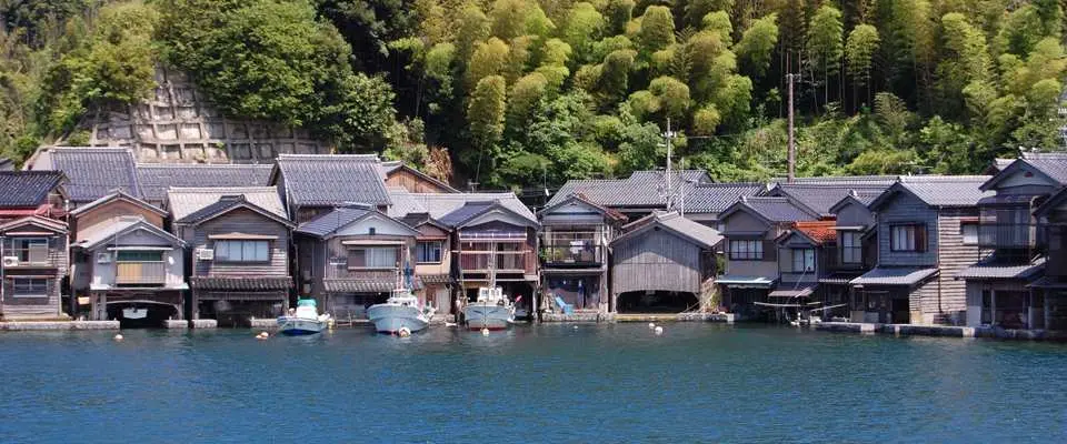 「伊根」 伊根位於京都北邊的丹後半島，臨海小漁村街道寧靜、純樸，其傳統建築「舟屋」是一大特色，不同於一般平房在一樓設置車庫，舟屋的一樓是船庫，二樓才是日常生活居所，行程安排以搭乘遊覽船的方式，從船上來欣賞舟屋的特殊建築，特別贈送蝦味先可以在船上餵食海鷗和老鷹，建議攜帶手套預防受傷又防曬