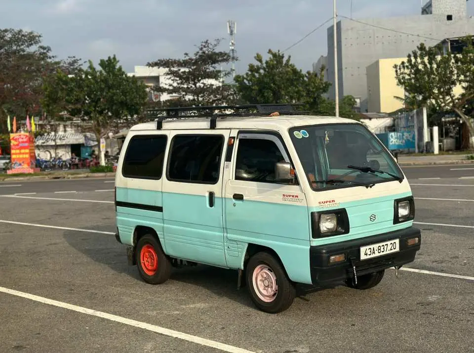 A light blue and white vintage-style van, providing convenient transportation for participants of the Da Nang stand-up paddleboard (SUP) experience, ensuring a smooth tour.