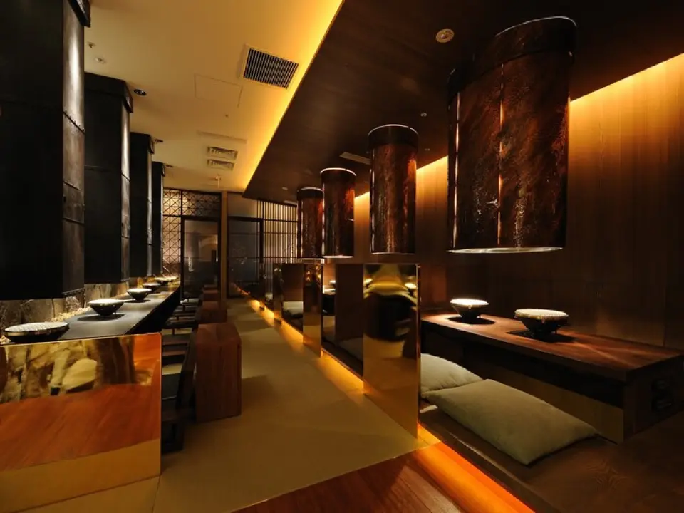 餐廳內部以石材和金色元素為主，營造出「至臻待客」的氛圍，打造出一個精緻典雅、尊貴典雅的空間。一排排來自不同生產商的木質標籤，更令人對極致體驗充滿期待。在至臻至美的環境中，盡享頂級美味。請放鬆身心，盡情享受。