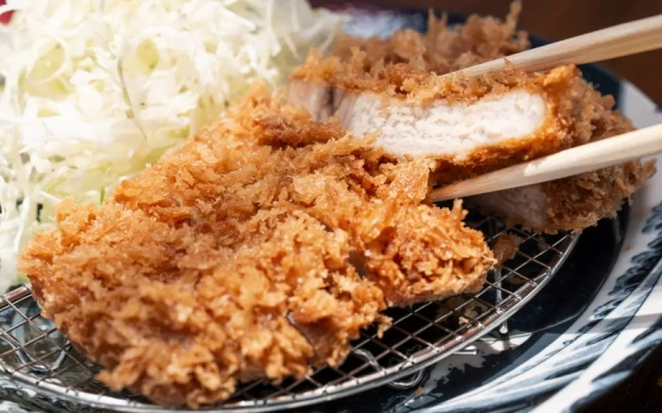 我們炸豬排的主要原料選用的是產自山形縣的“莊內豬肉”，這種豬肉生長在自然環境優越的地方。莊內豬肉肉質細緻鮮嫩，這是其獨特的特色。其脂肪質地香甜，熔點低，越嚼越香，在口中散發出濃鬱醇厚的風味。為了充分展現莊內豬肉肥瘦比例的完美平衡，我們對每一塊肉都經過精心處理，確定了最佳的厚度和烹飪時間。