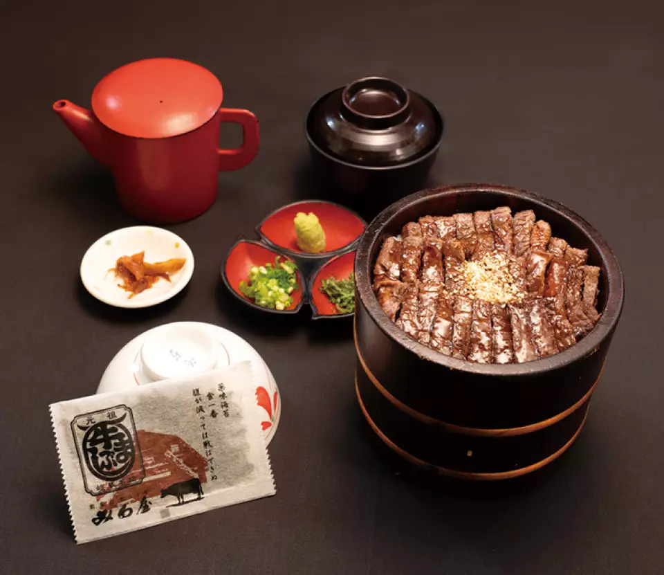 我們引以為傲的「飛驒牛肉麻布仕」是一道香氣四溢的料理，將牛肉多次塗抹特製醬汁後烤製而成。首先，您可以品嚐牛肉本身的鮮美滋味，然後添加各種佐料，體驗不同的風味。最後，淋上熱騰騰的肉湯，如同享用茶泡飯一般。這道菜盛放在電飯煲中，您可以根據自己的喜好將其掰碎食用。請盡情享受這道岐阜特色美食吧！