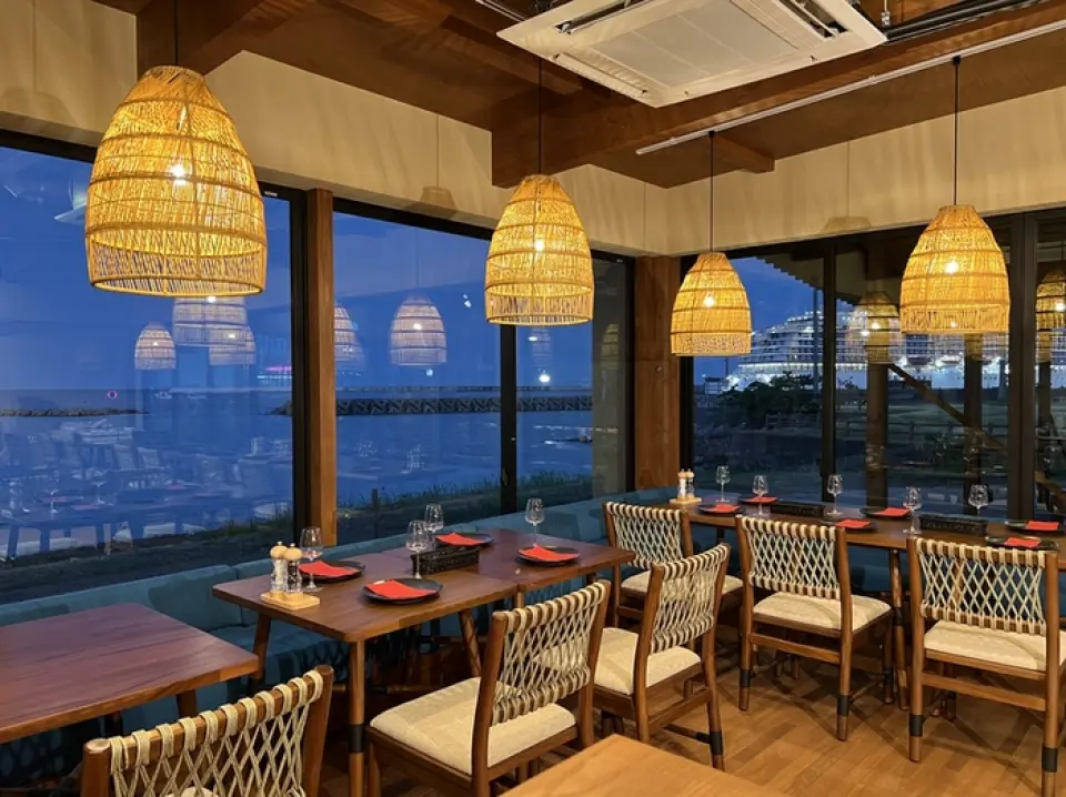 我們的餐廳位於上仁公園內，距離別府大學站步行僅需5分鐘。餐廳擁有玻璃帷幕牆，以大海為背景，您可以在享受美食的同時，感受寧靜祥和的氛圍。我們推薦您選擇露台座位，這是一個被自然環繞的開放空間。餐廳共有六張餐桌，另設一間可容納六至八人的私人房間，為您提供私密舒適的用餐環境。無論是約會、日常用餐，還是旅途中的早餐、午餐或晚餐，我們都歡迎您的光臨。