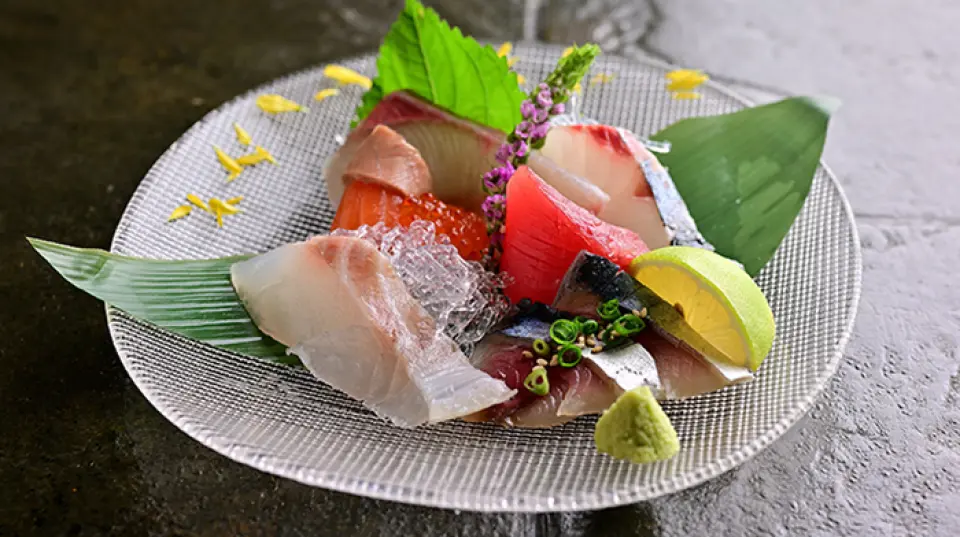 我们引以为傲的刺身采用独特的制作技法，充分展现每种鱼的风味和香气，同时尊重其独特性。我们的刺身拼盘尤其受欢迎，让您一次品尝到多种美味。请尽情享受当季食材带来的丰富滋味。