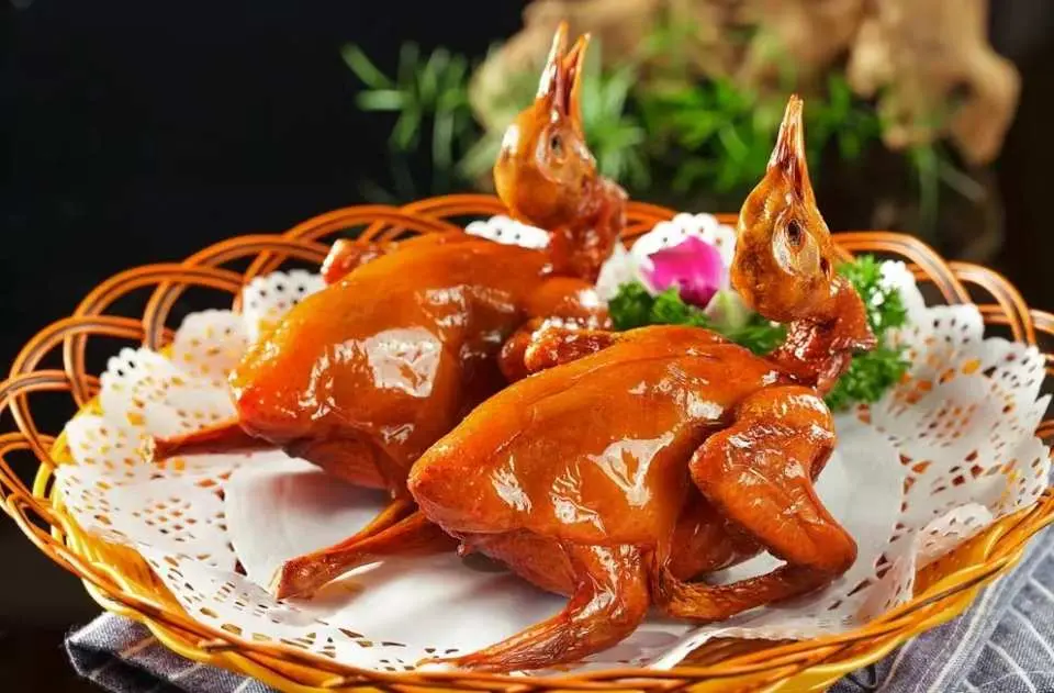 中山短線團特色美食【雀籠紅燒石岐乳鴿】特寫，金黃酥脆的乳鴿完美呈現，展現豐盛的團餐體驗。