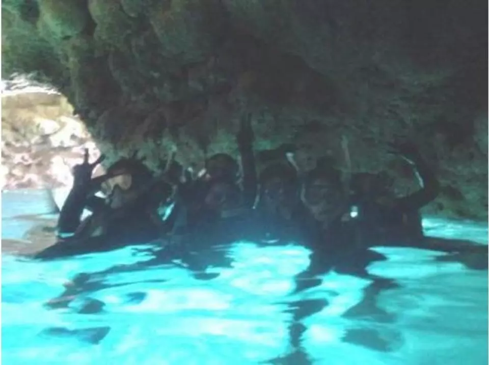 Inside the cave, the sea surface glows blue.