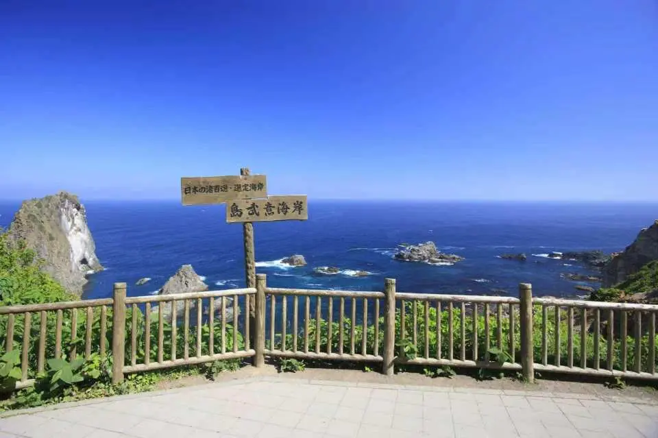島威海岸 ― 日本屈指の海岸線100選に名を連ねる、隠れた楽園。トンネルを抜けると、驚きの光景が待っています。暗く神秘的な手彫りの通路を抜けると、まるで絵画のように息を呑むほど美しい青い海の景色が目の前に広がります！