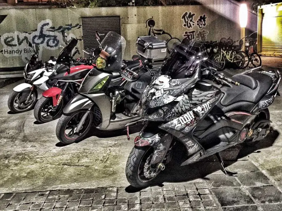 Four different international heavy motorcycles parked in Taipei at night, showcasing the unique styles of various models, ready for the next adventure.