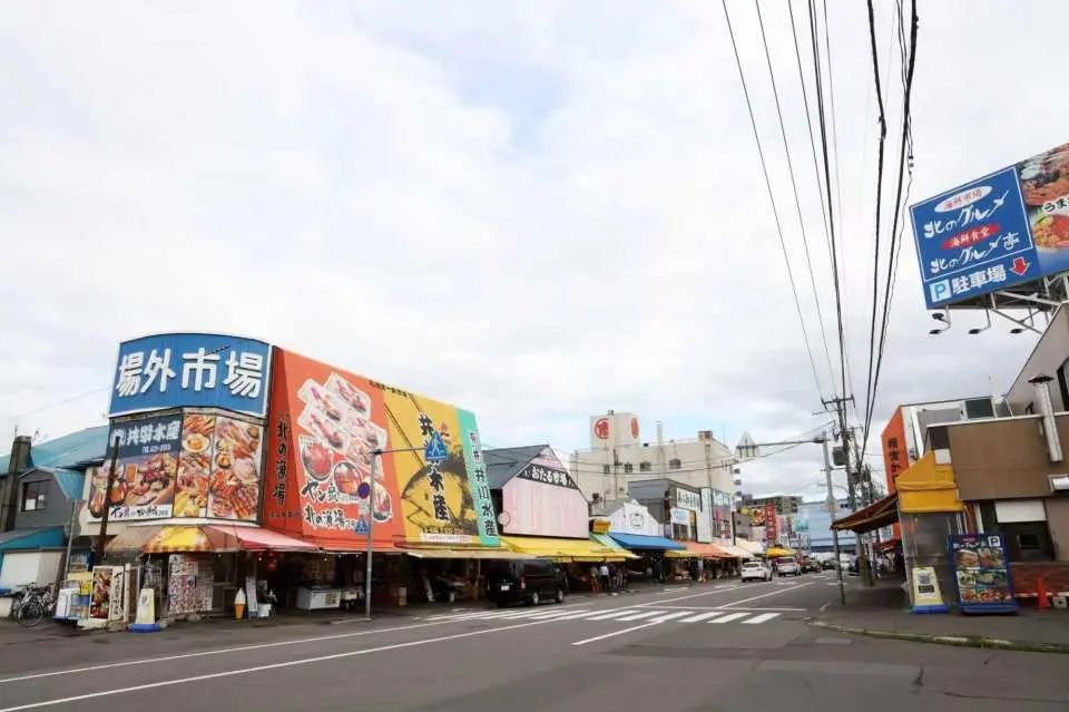 札幌中央批發市場中具有懷舊氣息的街景，這裡便是吃貨們來到北海道必打卡的「場外市場」。街道兩旁整齊排列著數十家歷史悠久的水產店與蔬果攤。在這裡，您不僅能感受到北海道商販的熱情叫賣，更能輕鬆找到那些隱藏在小巷裡的高分神級海鮮丼飯。