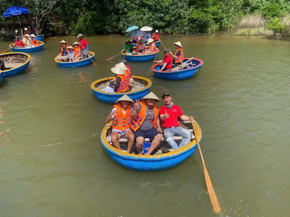 Tourists smiling on a traditional basket boat while enjoying a nature-based eco tour on the river in Phu Quoc.
