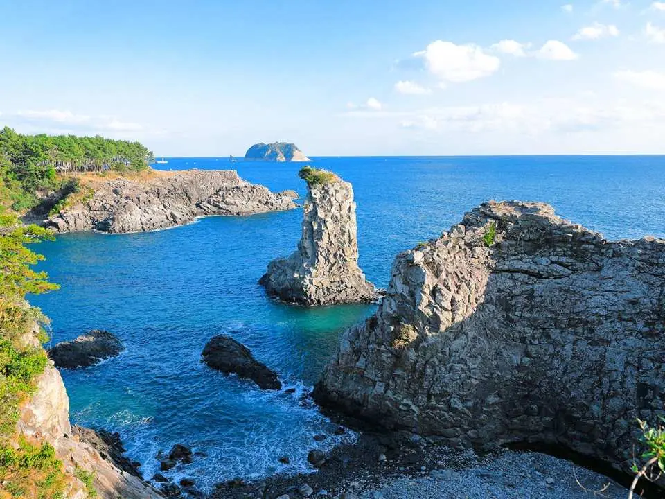 Gaze upon the iconic Oedolgae Rock, a lonely yet magnificent sentinel of the southern coast that rises uniquely from the ocean. Its dramatic silhouette and the crystal-clear water surrounding it make it one of the most famous and scenic photo spots in all of Jeju.