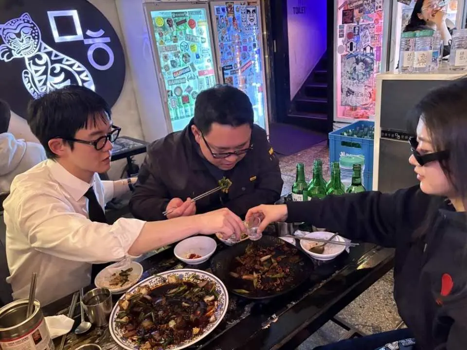 ソウルの伝統的な韓国式焼肉レストランで、ビジネススーツを着た韓国人ビジネスマンと一緒に美味しい食事をお楽しみください。