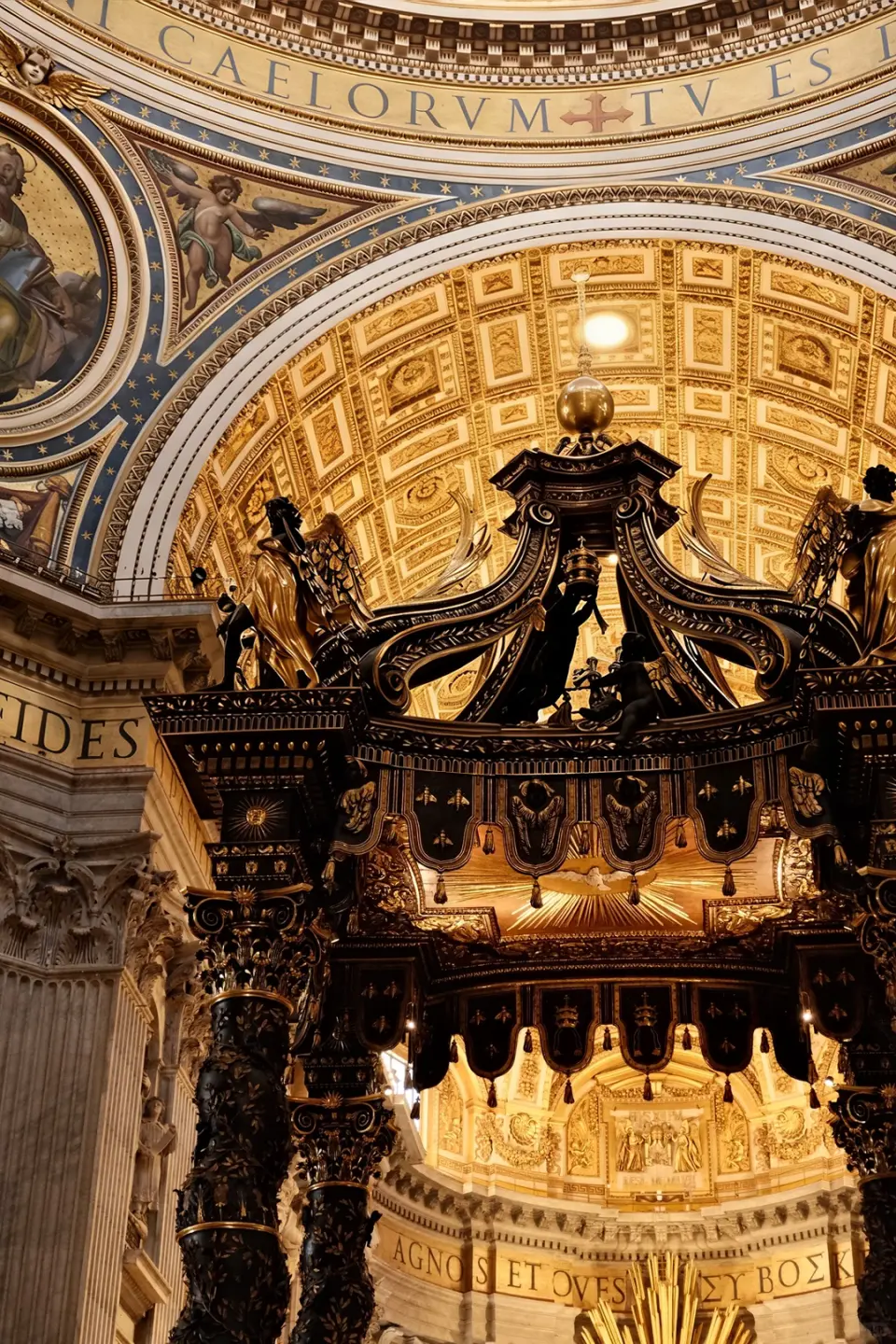 第三站：圣彼得大教堂 (Basilica di San Pietro)
——“尘世间趋于接近天堂的建筑”
走出博物馆，穿过圣彼得广场的石柱廊，步入这座世界最大的教堂。阳光从巨大的穹顶（Cupola）洒下，形成丁达尔效应，那一刻你会明白“神圣”的物理定义。
•《圣殇》(Pietà)：米开朗基罗 24 岁时的成名作。圣母玛利亚怀抱受难后的基督，那大理石被打磨出的丝绸质感，是哀恸中的极致温柔。
•圣彼得华盖：贝尔尼尼设计的巨大青铜华盖，盘旋向上的扭曲柱身，展现了巴洛克艺术最繁复、最戏剧性的张力。
•登顶时刻：爬上 551 级台阶，俯瞰钥匙形状的圣彼得广场。罗马城的日落，会将这片文明的厚重染成温暖的橘红色。